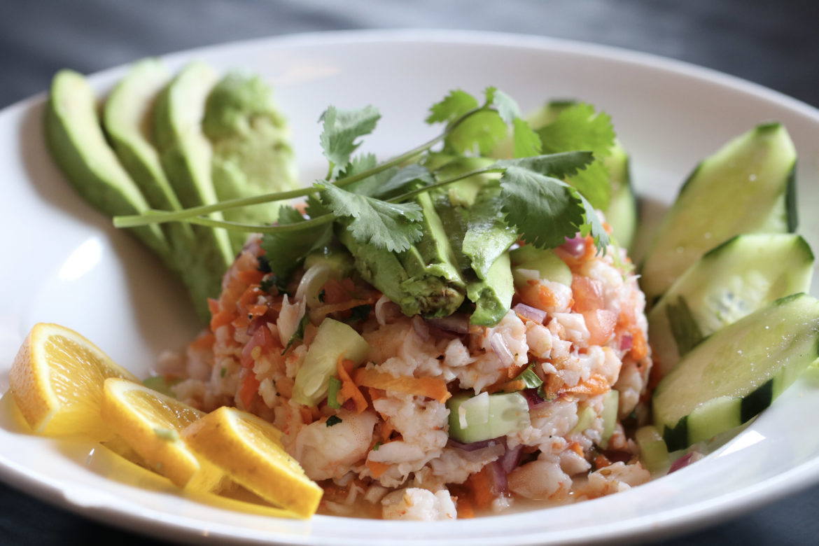 Shrimp Ceviche surrounded by cucumbers, avocado slices, and orange slices.