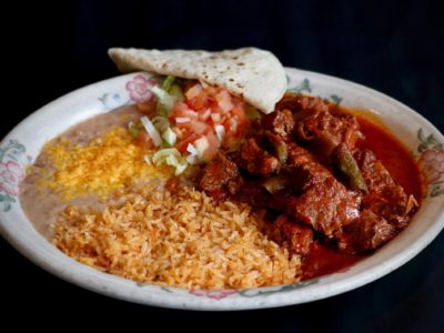 Chile Colorado: Beef simmered until very tender in a red sauce, tomatoes, onions, mild peppers and spices served with rice and beans.