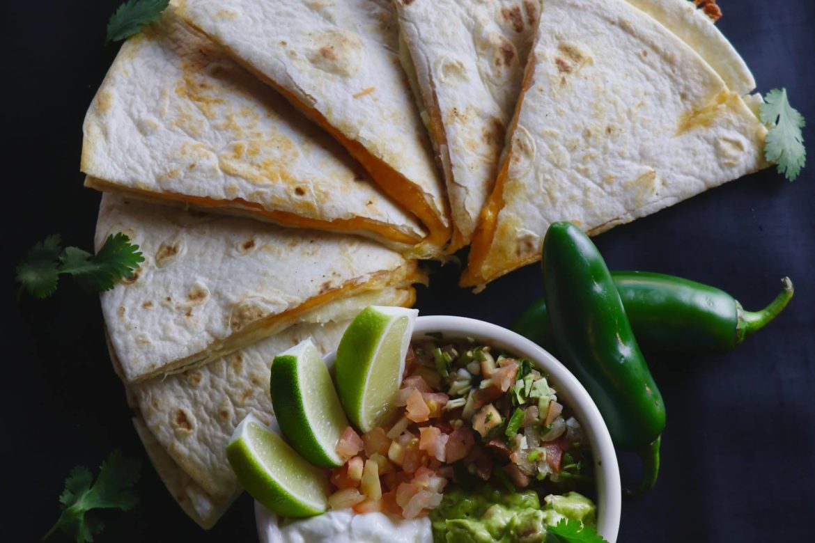 Cheese Quesadilla with a side dish with jalapenos.