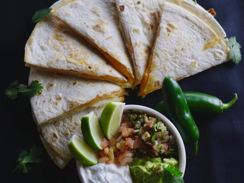 Cheese Quesadilla with a side dish with jalapenos.