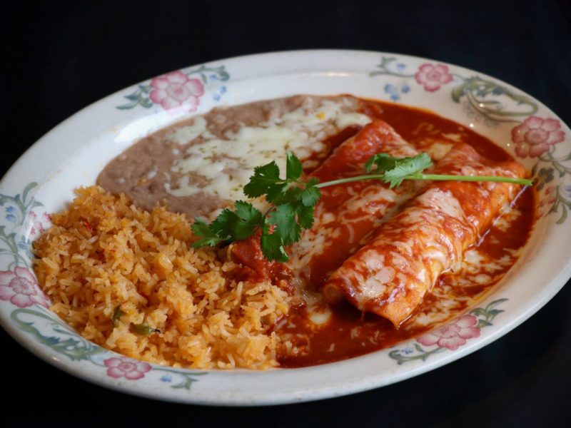 Mole Enchiladas: Two tortillas, filled with you choice of meat topped with sweet “Mole” sauce and Jack cheese served with rice and beans.