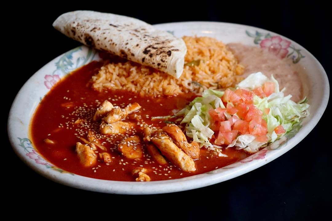 Chicken Mole: Sliced chicken breast specially prepared with fresh mushrooms, onion and green pepper served on a bed of rice with Jack cheese, smothered with our special mild sauce, garnished with avocado and tomatoes.